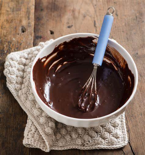 Chocolate cake batter in a bowl with a whisk