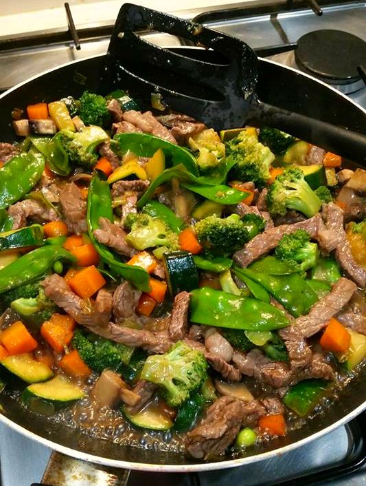 Beef stir fry in a pan cooking on the stove